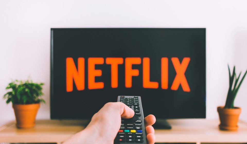 person holding remote pointing at TV